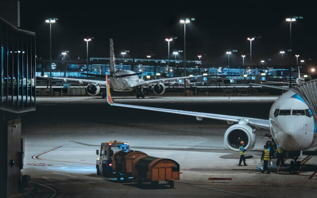 An airport at night with several planes parked