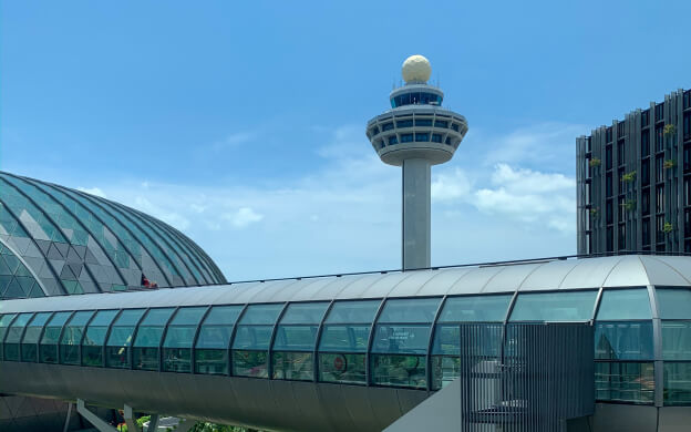 An external view of an airport with an ATC tower in the distance