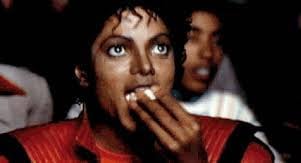 A screenshot taken from Michael Jackson’s music video for ‘Thriller’. Michael is eating popcorn in a cinema.